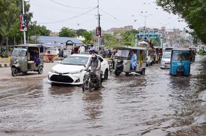 Vehicles trying to make their way through rainwater accumulated on Jail Road following heavy rainfall.