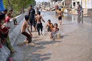 Canal water floods a road in Jinnah Colony following an overflow, disrupting traffic and commuters.