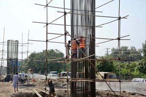 Labourers busy in construction work on Jaranwala Road during development work in metro project.