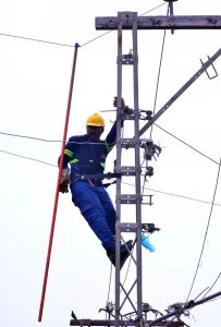 A HESCO worker removes an illegal electricity hook connection during an anti-theft drive in the Old Subzi Mandi area.