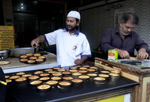 A baker prepares a freshly baked, flavourful tandoori cake at a tandoor in the Kartarpur area of the twin cities.