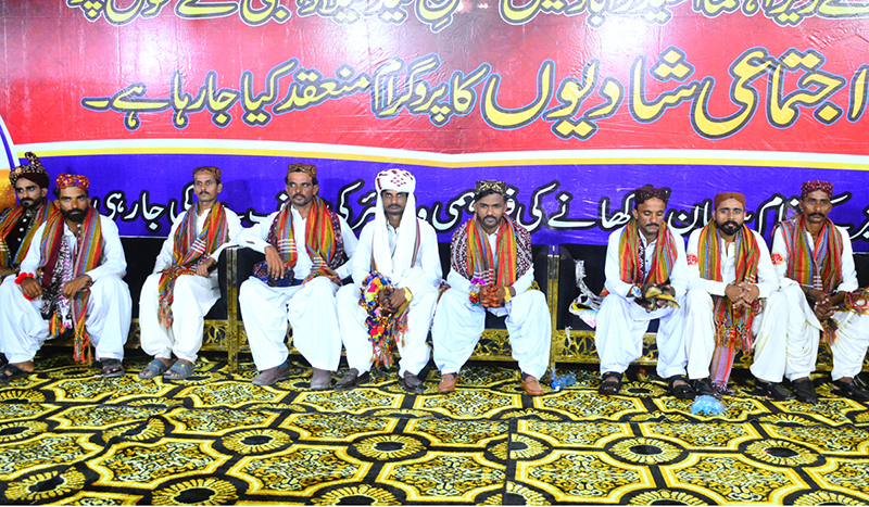 Grooms sitting on stage during a mass wedding ceremony organized by Jillani Welfare Foundation at Bagh-e-Mustafa Ground