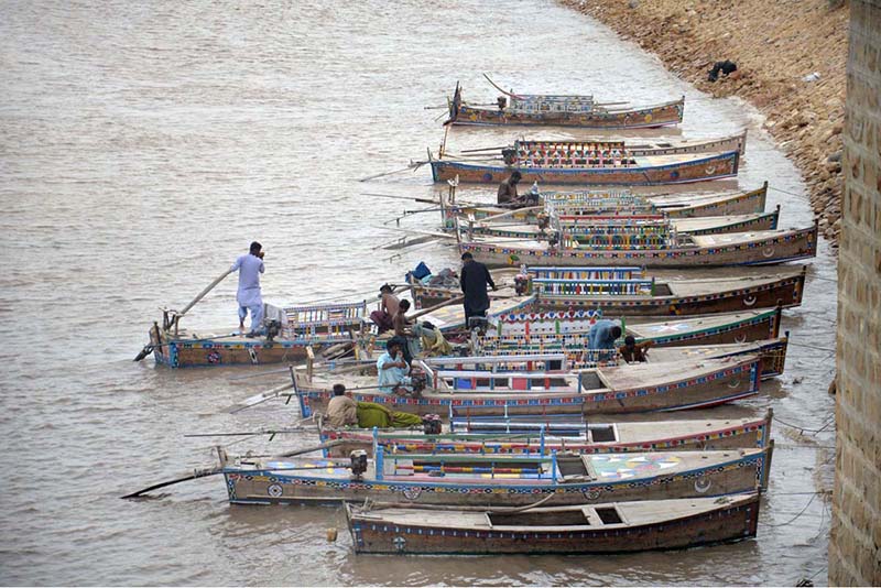 A large number of boats are parked on the bank of the Indus River at Al-Manzar picnic point