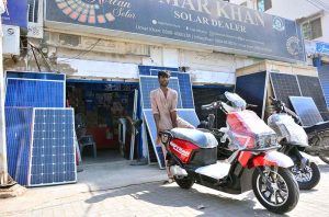 A vendor displaying electric bikes and solar panels outside his shop at Station Road.