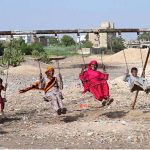 Gypsy women with her children enjoying the swing at Makki Shah Area