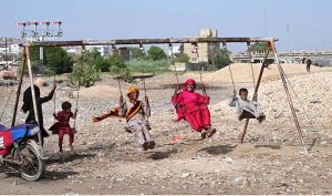 Gypsy women with her children enjoying the swing at Makki Shah Area