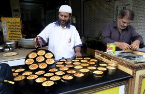 A baker prepares a freshly baked, flavourful tandoori cake at a tandoor in the Kartarpur area of the twin cities.
