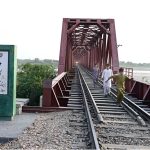 Youngster are running on the Mehran Railway Bridge as the train approaches near Husenabad