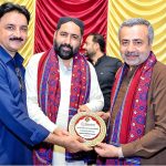 Chief Guest and PPP leader Sardar Tariq Anwar Khan Siyal, along with renowned Sindhi poet Gulfam Gul Sangi, presents a shield to APP Larkana photographer Nadeem Akhtar Soomro in recognition of his outstanding coverage of the Sindh Theatre Festival 2026 during the closing ceremony at Z.A. Bhutto Open-Air Theatre, Arts Council Larkana