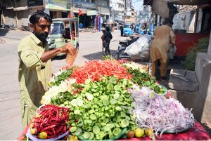 A handcart vendor displays fresh salad to attract customers along Saddar Road