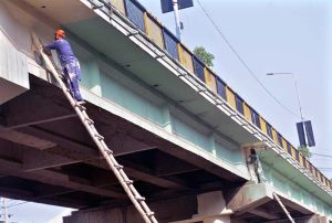 Workers paint the Kalma Chowk Flyover as part of a beautification drive to enhance the city’s appearance.