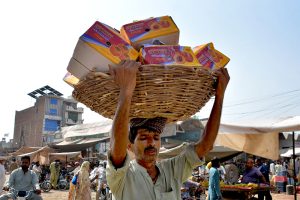 Labourers unload heavy sacks of onions from a delivery truck at the city’s vegetable market, reflecting the hectic activity involved in the daily supply of fresh produce