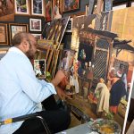 An artist busy in artwork at his setup in Lok Virsa