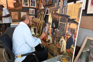 An artist busy in artwork at his setup in Lok Virsa