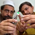 Gemologists are examining q precious Emeralds at a workshop in the Sarafa Bazaar is a renowned worldwide for the gemstone trade