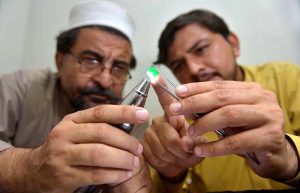 Gemologists are examining q precious Emeralds at a workshop in the Sarafa Bazaar is a renowned worldwide for the gemstone trade