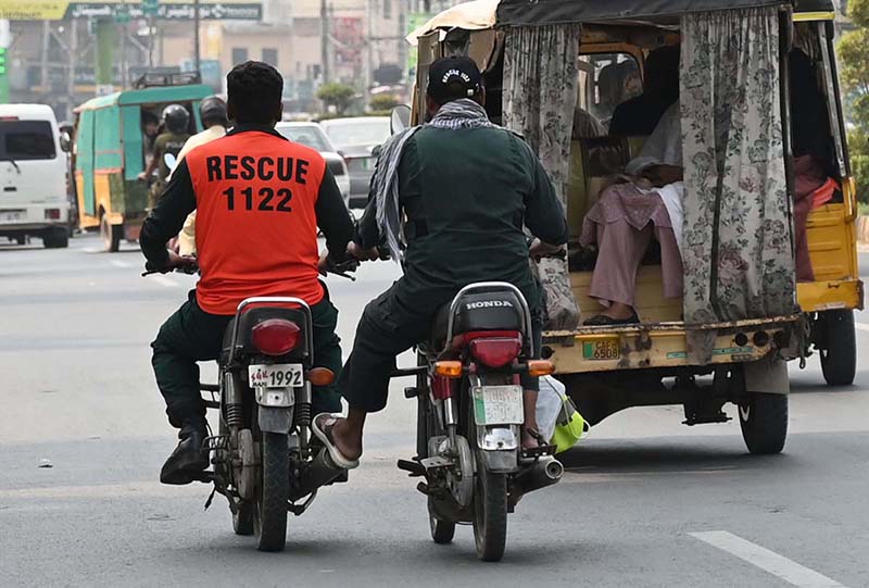A motorcyclist pushes a Rescue 1122 motorcycle at Club Chowk