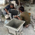 Labourers make cement plants pots for gardening at their work place near Shahdara Marble Market