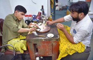 Gemologists are examining q precious Emeralds at a workshop in the Sarafa Bazaar is a renowned worldwide for the gemstone trade