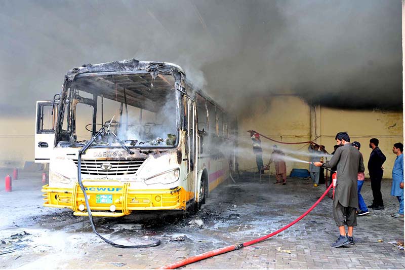 Firefighters struggles to extinguish fire that erupted in a bus after a blaze broke out in the parking area of Government College Women University Faisalabad (GCWUF), caused by the battery of an electric scooter exploding while charging