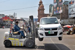 A traffic warden removes a wrongly parked car with a forklift at Ghanta Ghar Chowk to facilitate smooth traffic flow.