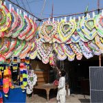A vendor displays garlands made of currency notes used in wedding ceremonies to attract customers in front of his shop