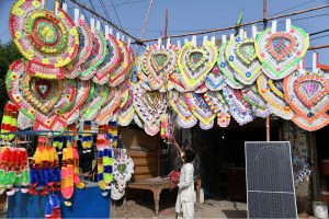 A vendor displays garlands made of currency notes used in wedding ceremonies to attract customers in front of his shop