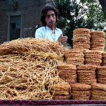 A street vendor arranging and displaying the snacks on his hand cart to attract the customers on their handcart at the roadside setup