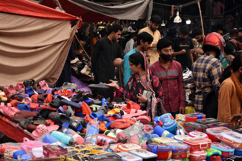 Woman Shops for Lunchboxes and Slippers for Her Children at Naulakha Bazaar