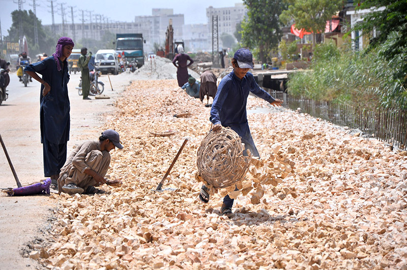 Labourers are busy their work during road construction as part of development work at Autobahn Road