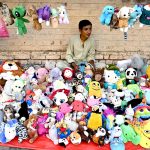 A roadside vendor waits for customers while displaying second-hand toys to attract passersby at his stall in the provincial capital