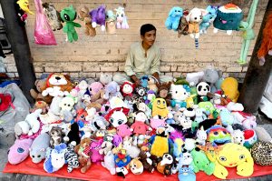 A roadside vendor waits for customers while displaying second-hand toys to attract passersby at his stall in the provincial capital