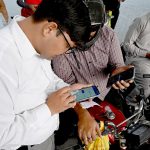 A petrol pump employee verifies a token number from mobile message presented by a motorist to confirm eligibility for subsidized fuel under the Prime Minister’s petrol relief package