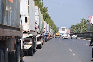 Commuters ride past shipping containers stacked in front of Serena Hotel as authorities beef up security ahead of PTI's expected long march