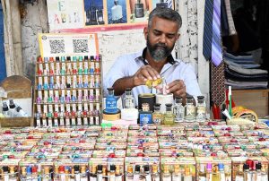 A vendor sells ittar (perfume) by the roadside in old Anarkali