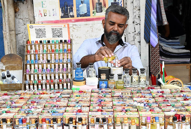 A vendor sells ittar (perfume) by the roadside in old Anarkali