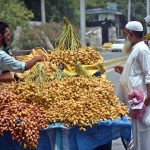 A vendor displays and sells dates at a roadside stall to attract customers