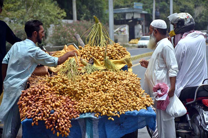 A vendor displays and sells dates at a roadside stall to attract customers