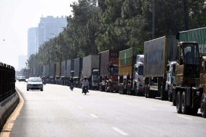 Commuters ride past shipping containers stacked in front of Serena Hotel as authorities beef up security ahead of PTI's expected long march