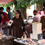 People select and purchase old books from a book stall at Mall Road