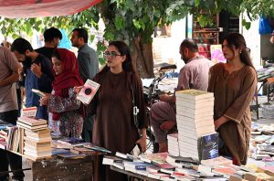 People select and purchase old books from a book stall at Mall Road