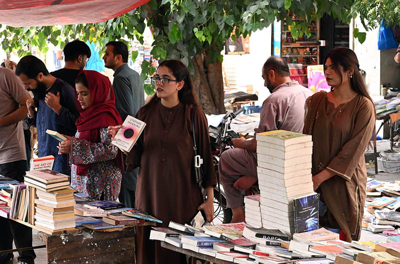 People select and purchase old books from a book stall at Mall Road