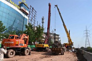 Heavy construction machinery including excavators and cranes are deployed at the service road construction site along the Expressway, as development work continues to improve the road infrastructure in the Federal Capital