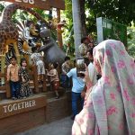 A woman takes photos of children with her mobile phone at the zoo