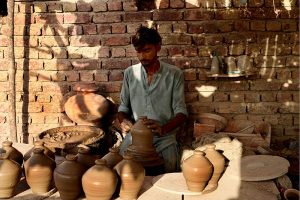 A worker is busy preparing clay-made items at his workplace in Kumhar Pura