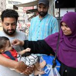 A lady health worker administers polio drops to a child at Patiala Ground Road