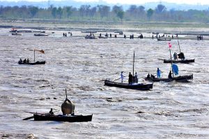 Fishermen busy in fishing on the boats at Indus River.