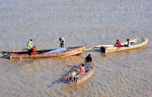 Fishermen busy in fishing on the boats at Indus River.