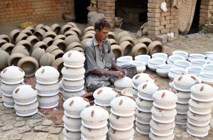 A potter makes clay cooking pots and other earthenware at his workplace in the provincial capital.