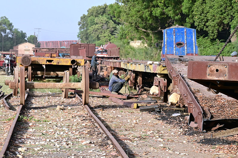 Railway workers are busy welding while repairing a goods train at Kotri Railway Workshop